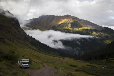 High angle view of travel trailer against San Juan Mountains during foggy weather - CAVF31679