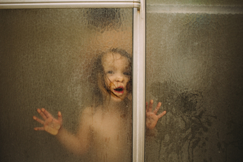 Porträt eines Mädchens in der Dusche durch Glas gesehen, lizenzfreies Stockfoto