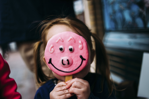 Close-up of girl hiding face with candy stock photo