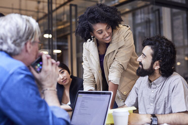 Happy businesswoman looking at male colleague during meeting - CAVF32015