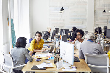 Hoher Blickwinkel auf Geschäftsleute, die sich bei der Arbeit in einem kreativen Büro unterhalten - CAVF32029