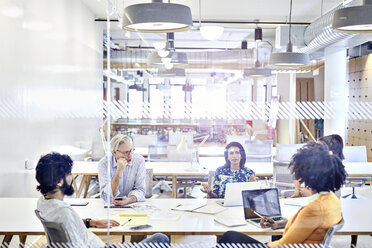 Business people having meeting at conference table seen through window - CAVF32061