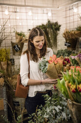 Frau wählt Blumen im Geschäft aus - FOLF05973