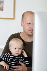 Stay at home dad with baby son using computer - FOLF05995
