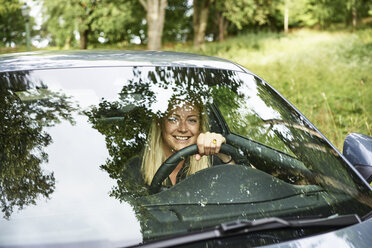 Smiling woman travelling by car in countryside - FOLF06092