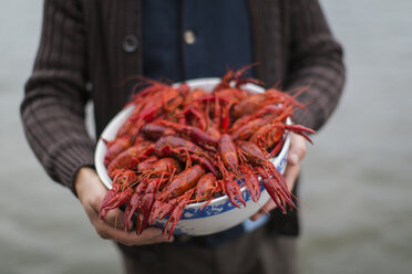 Mid section of man holding bowl of crayfish - FOLF06148