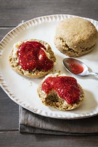 Scones made of einkorn wheat with strawberry jam and clotted cream stock photo