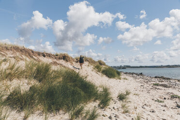 Frankreich, Bretagne, Landeda, Dunes de Sainte-Marguerite, junge Frau beim Spaziergang in einer Düne an der Küste - GUSF00579