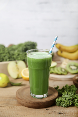 Green smoothie surrounded by ingredients stock photo