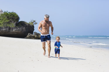 Father and son running on Diani Beach, Kenya - FOLF06205