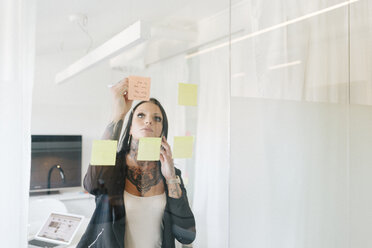 Woman putting notes on window - FOLF06230