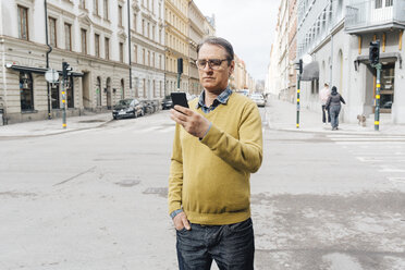 Man holding a smart phone on a street - FOLF06250