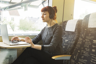 Woman using laptop on train - FOLF06278