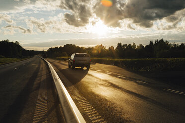 Auto auf einer Landstraße bei Sonnenuntergang - FOLF06284