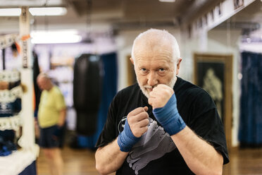 Älterer Mann mit erhobenen Fäusten beim Boxtraining - FOLF06300