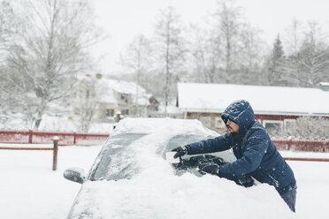 Mann räumt Schnee von seinem Auto - FOLF06370