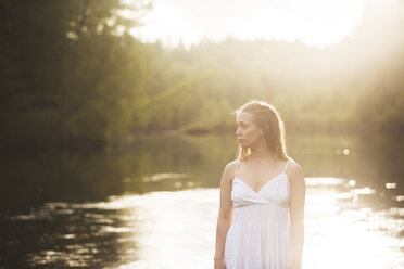 Woman wearing white dress by river - FOLF06410