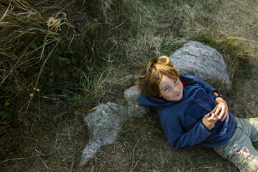 Young boy lying down against Rock - FOLF06569