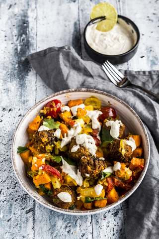 Vegetarische Schale mit Süßkartoffel, Tomate und Falafel, Joghurt-Dip und Petersilie, lizenzfreies Stockfoto