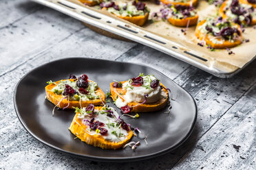 Slices of sweet potato with cream cheese, ramson cream, goat cheese, cress and cranberries - SARF03646