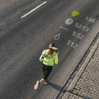 Young woman running on a street with data - UUF13176