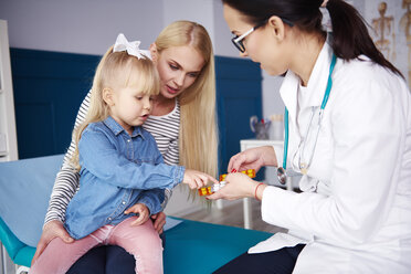 Girl receiving tablets from doctor in medical practice - ABIF00216