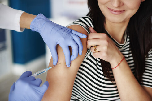 Woman receiving an injection in her arm - ABIF00235