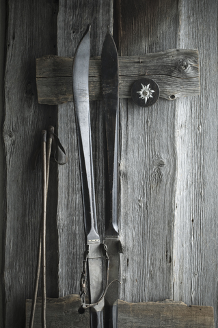 Alte Skier und Skistöcke lehnen an einer Holzwand, Edelweiss, lizenzfreies Stockfoto