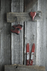 Alte Kinderskier, die an einer Holzwand lehnen, Skischuhe und ein rotes Herz - ASF06167