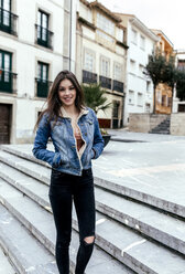 Portrait of a smiling brunette woman in a town - MGOF03755