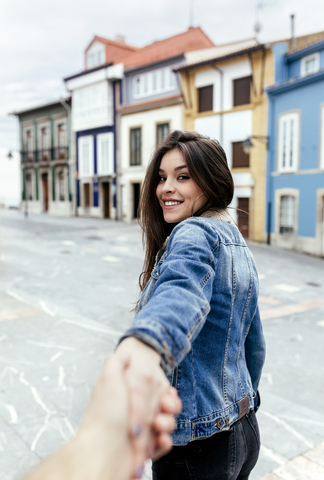 Porträt einer lächelnden brünetten Frau mit Hand in einer Stadt, lizenzfreies Stockfoto