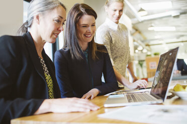 Geschäftsfrauen mit Blick auf Laptop-Computer auf dem Tisch im Büro - CAVF32192