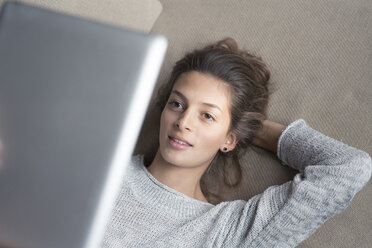 Frau auf Couch liegend mit Tablet - PNEF00577