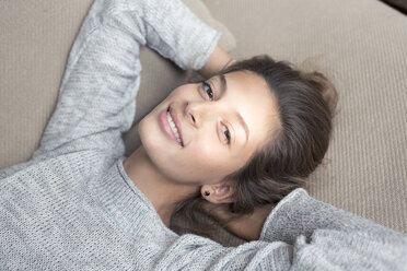 Porträt einer lächelnden Frau auf einer Couch liegend - PNEF00579