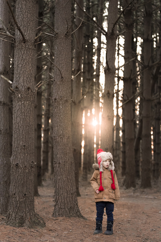 Nachdenklicher Junge im Wald stehend, lizenzfreies Stockfoto