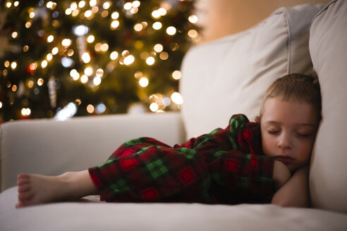 Full length of boy sleeping on sofa during Christmas - CAVF32385