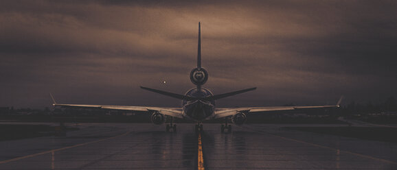 Flugzeug, das von der Startbahn gegen den bewölkten Himmel bei Sonnenuntergang abhebt - CAVF32399