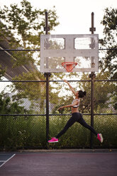 Sportliche Frau erreicht Basketballkorb - CAVF32464