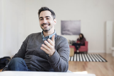 Close-up of smiling businessman sitting in office - CAVF32504