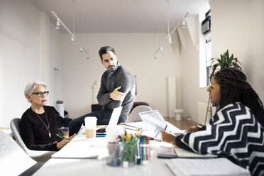 Geschäftsleute diskutieren am Tisch in einem kreativen Büro - CAVF32523