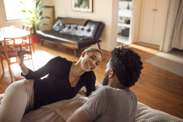 Hohe Winkel Ansicht der glücklichen Frau im Gespräch mit Mann im Schlafzimmer - CAVF32714
