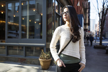 Thoughtful young woman standing on sidewalk - CAVF32765