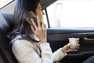 Seitenansicht einer Frau, die ein Smartphone im Taxi benutzt - CAVF32794