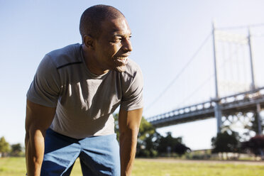 Tired man looking away while standing against Triborough Bridge - CAVF32933