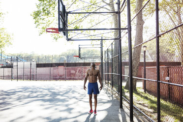 Mann schaut nach oben, während er im Basketballfeld steht - CAVF32944