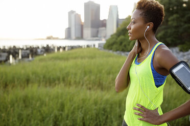 Athlete listening music while standing at park - CAVF32965