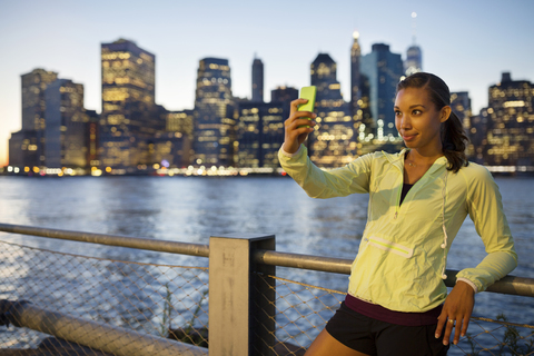 Sportler macht Selfie im Stehen am Fluss, lizenzfreies Stockfoto
