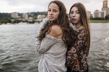 Porträt von Freundinnen, die in der Stadt am Fluss stehen - CAVF33030