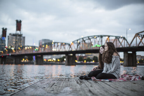 Freundinnen sitzen auf dem Pier vor der Burlington Northern Railroad Bridge 9.6 - CAVF33037