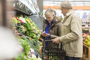 Älterer Mann sieht Frau an, die im Supermarkt steht und telefoniert - CAVF33202